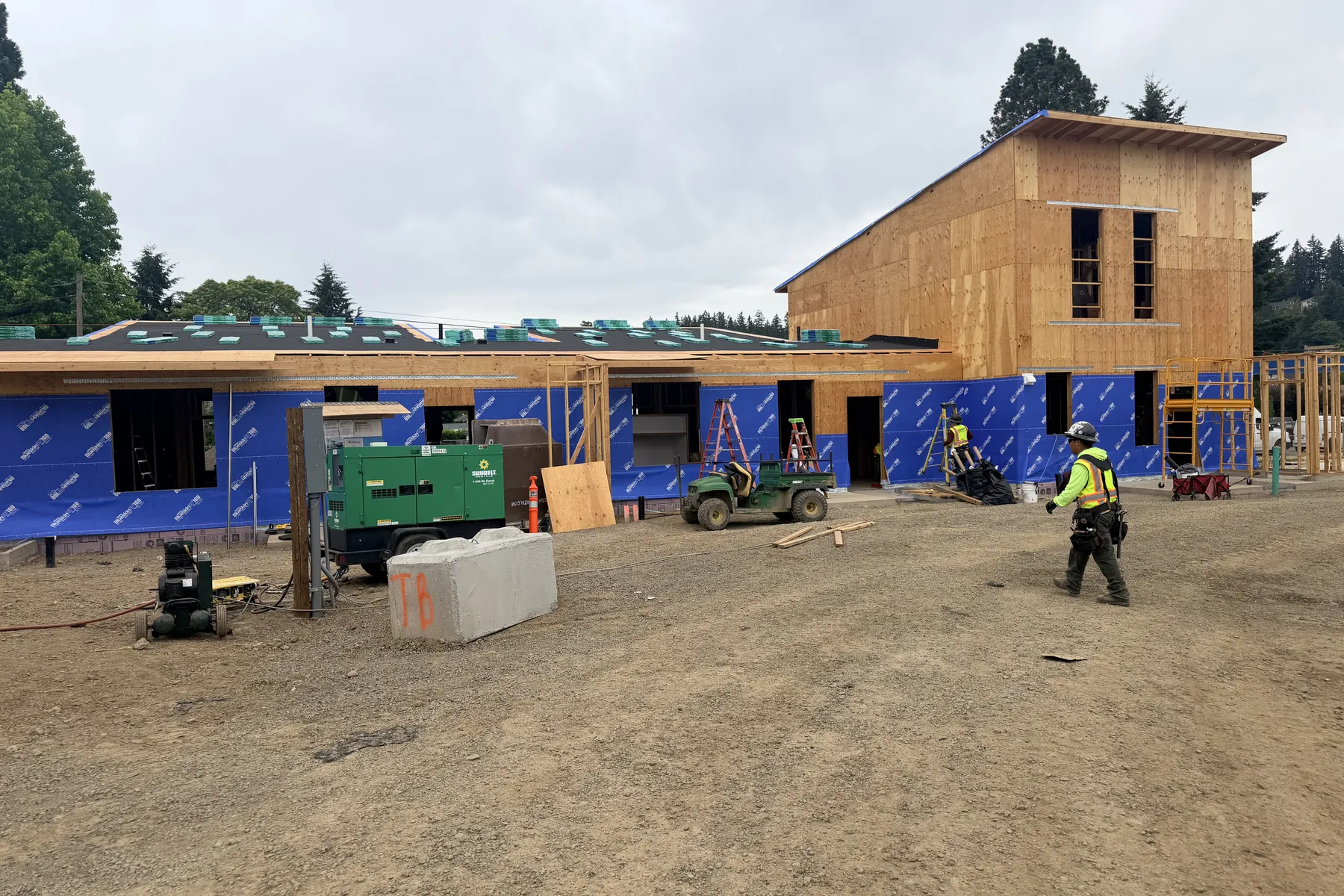 Framed buildings with weather barrier and a two-story sheathed section at Park Place